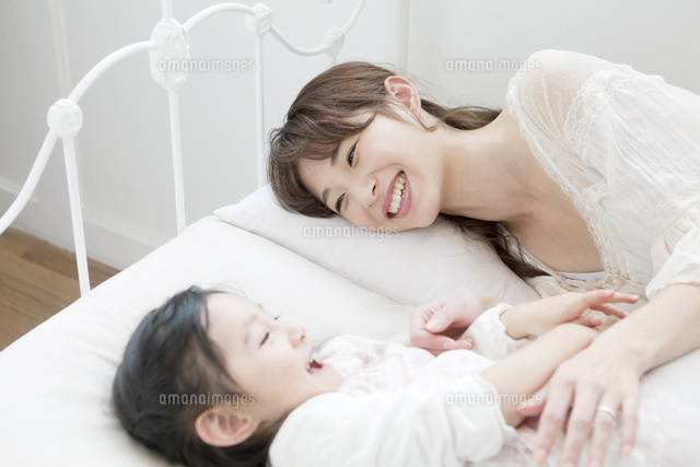 ベッドでくつろぐ母親と娘
(c)absodels RF