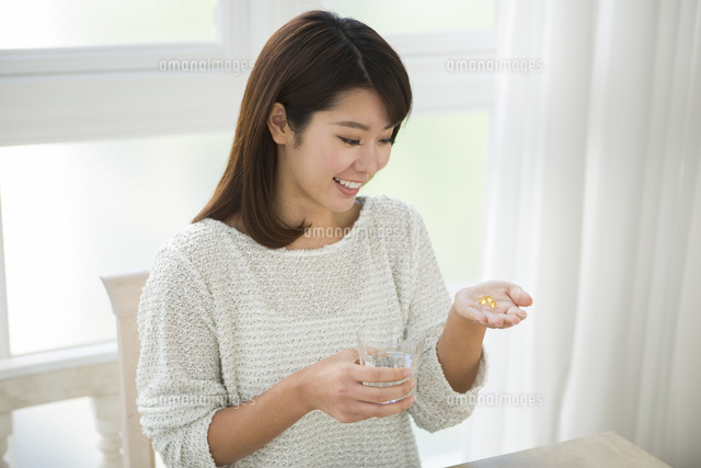 サプリメントを持つ20代女性
(c)absodels RF