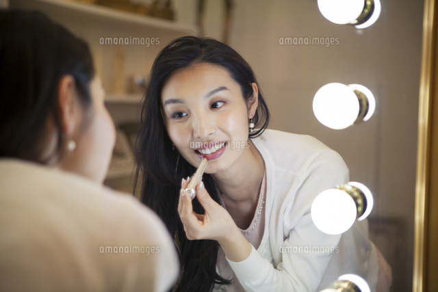 鏡に向かい化粧直しをする20代女性
(c)absodels RF