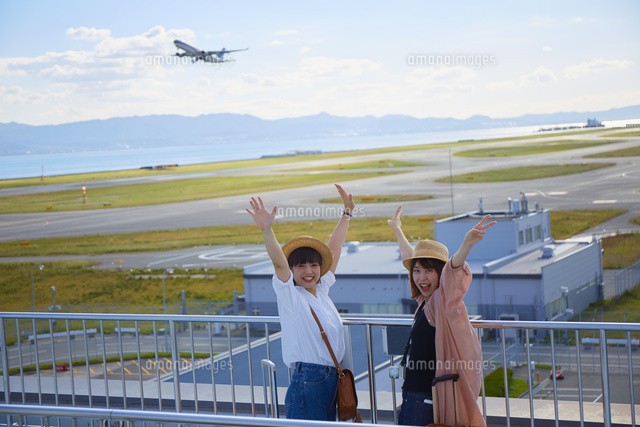 飛行場をバックにポーズを決める女性二人組 10179016347 の写真素材 イラスト素材 アマナイメージズ