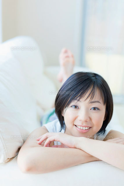 ソファに寝転ぶ女性
(c)Pholdar nine/a.collectionRF