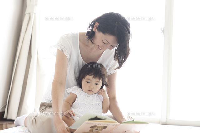 リビングで赤ちゃんを抱っこしながら絵本を読んであげる笑顔のお母さん
(c)KIYOKO FUKUDA/a.collectionRF
