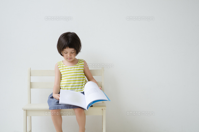 ベンチに座って絵本をめくる女の子
(c)Emi Komagata/a.collectionRF