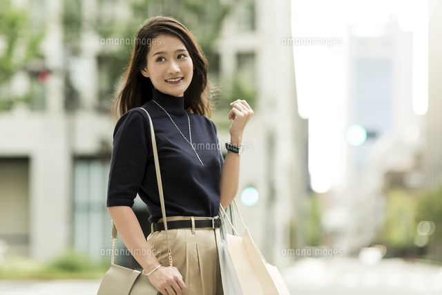 ショッピングバッグを持つ若い女性
(c)RYO