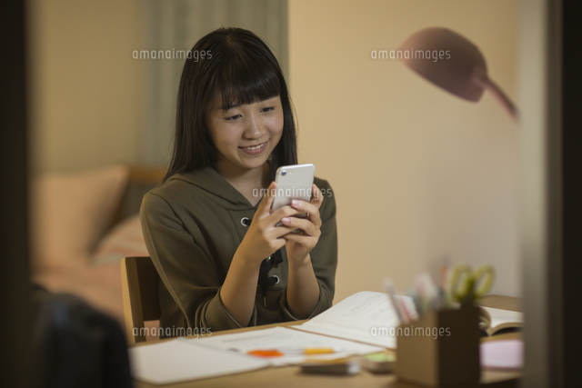 スマートフォンを見ながら勉強をする女の子
(c)RYO
