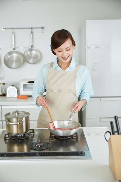 肉を焼くエプロン姿の女性
(c)forty-one/a.collectionRF