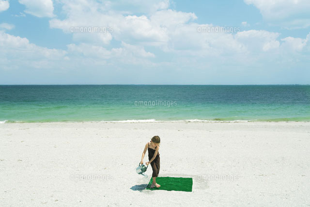Girl watering square of artificial turf
(c)Milena Boniek/Photo Alto