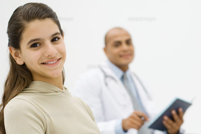 Teenage girl smiling at camera, doctor holding folder
(c)Odilon Dimier/PhotoAlto