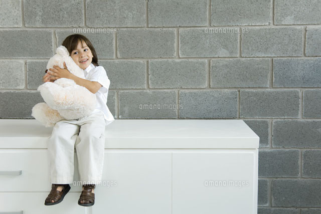 Little boy sitting on counter, hugging teddy bear
(c)Odilon Dimier/PhotoAlto