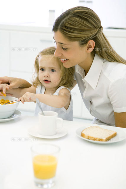 Mother and daughter sitting at table, eating breakfast
(c)Sigrid Olsson/PhotoAlto