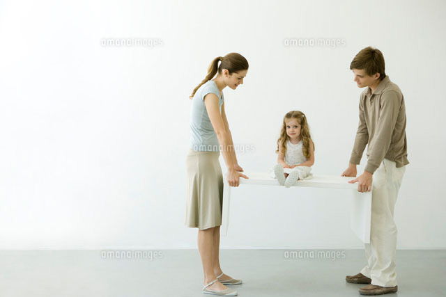 Young couple carrying table with daughter sitting on it
(c)Alix Minde/PhotoAlto