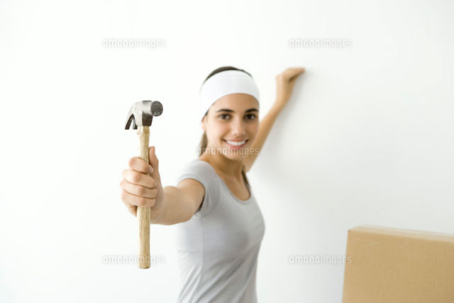 Teen girl showing hammer to the camera, smiling
(c)Alix Minde/PhotoAlto