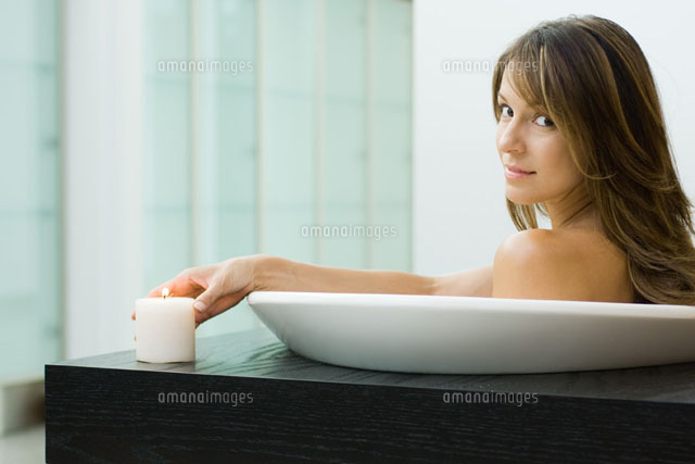 Woman sitting in bathtub,holding lit candle
(c)Odilon Dimier/PhotoAlto