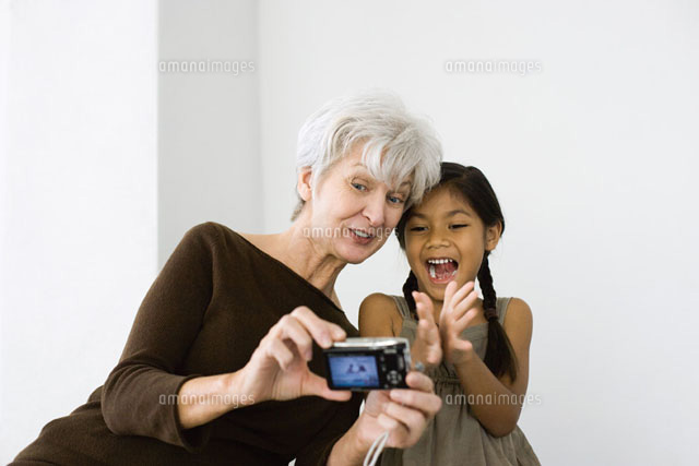 Woman photographing self and granddaughter with camera
(c)Frederic Cirou/PhotoAlto