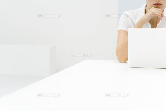 Woman using laptop computer,hand under chin,cropped view
(c)Alix Minde/PhotoAlto