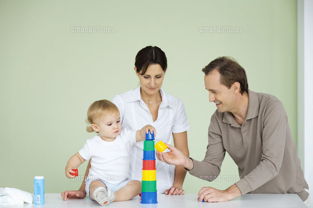 Toddler stacking plastic toys,parents watching
(c)Ale Ventura/PhotoAlto