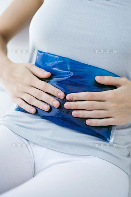 Woman holding ice pack against her stomach,cropped view
(c)Alix Minde/PhotoAlto