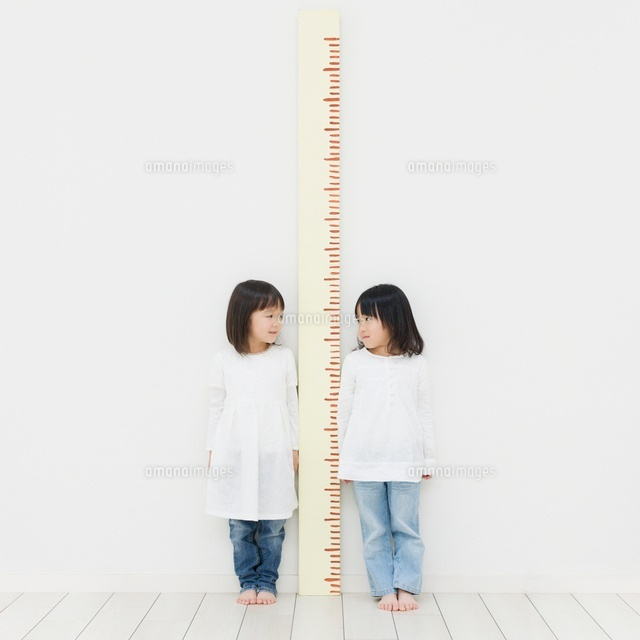 身長計に並ぶ2人の女の子 の写真素材 イラスト素材 アマナイメージズ