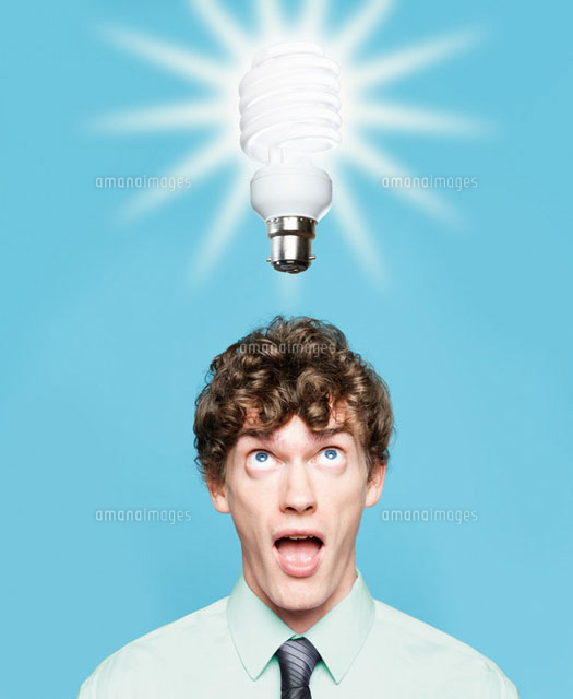 A young man looking at an energy saving lightbulb
(c)Image Source