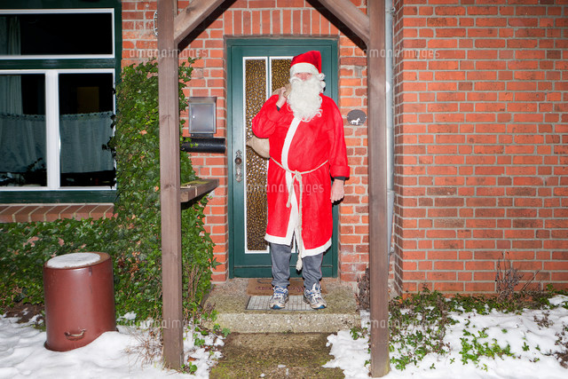 Man dressed as Santa Claus outside house
(c)Image Source