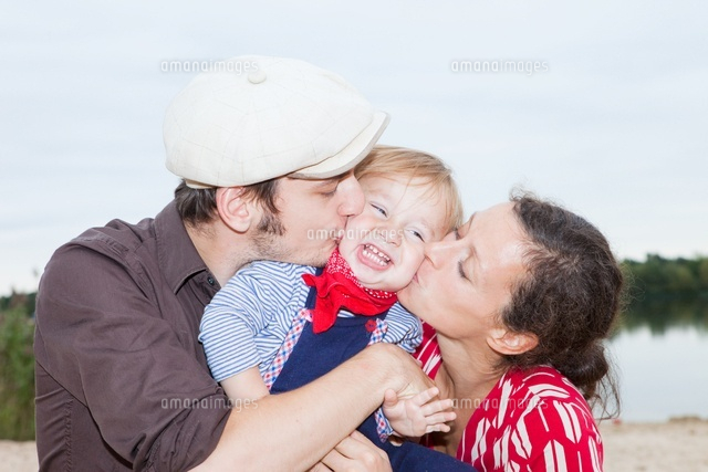 Couple kissing their young son on his cheeks
(c)Image Source