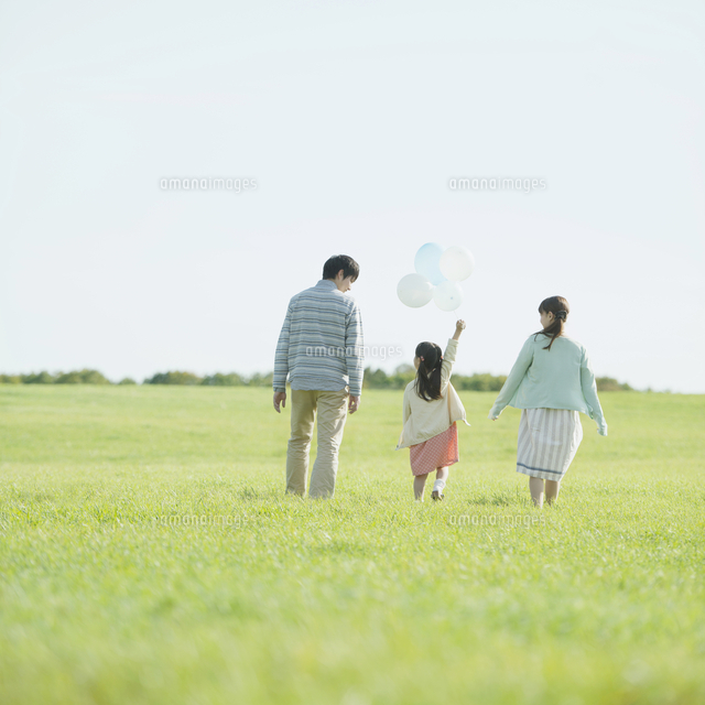 草原で風船を持ち歩く親子の後姿
(c)visual supple