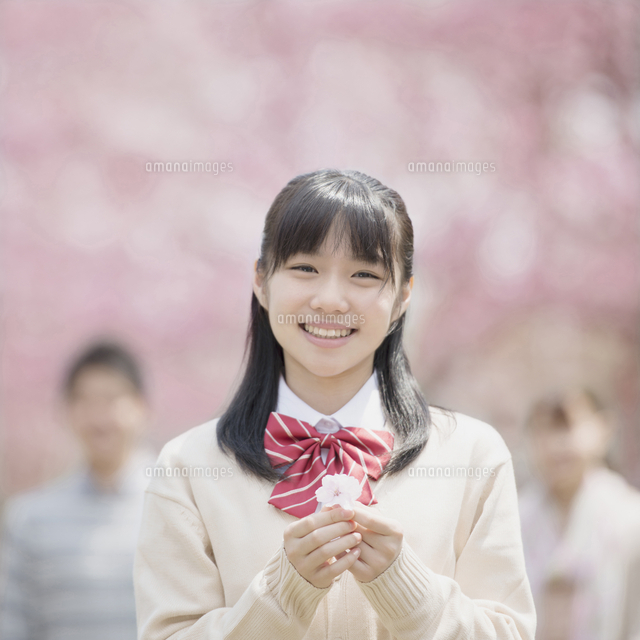 桜の花を持ち微笑む女子中学生
(c)visual supple