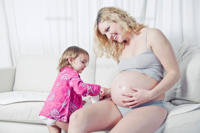 Pregnant Woman and Duaghter applying Cream to Stomach
(c)Radius Images