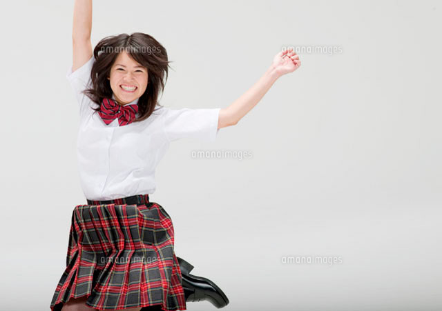 ジャンプをする制服姿の日本人女子高生
(c)didi