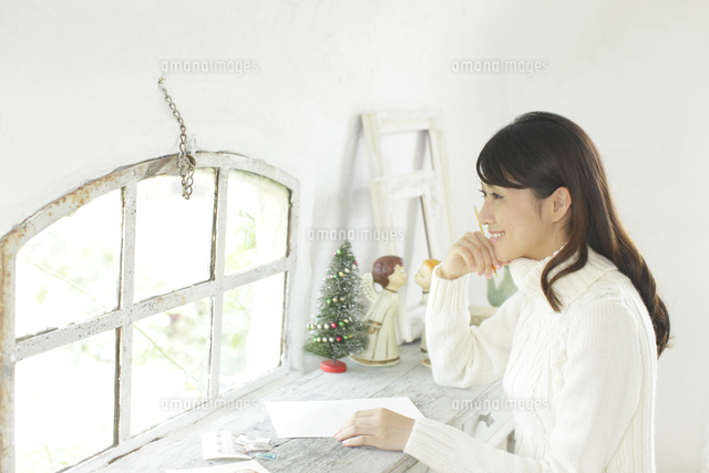 クリスマスカードを描く白いセーターの若い女性
(c)mon printemps
