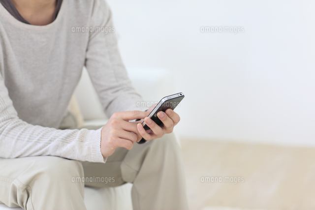 スマートフォンを操作する若い男性の手元
(c)mon printemps