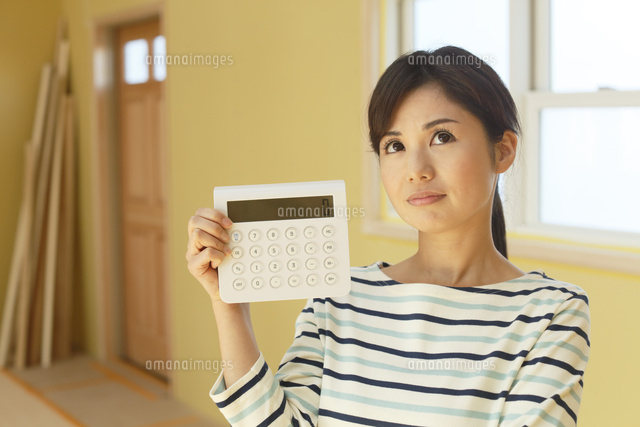 計算機を手に建築費用に悩む女性
(c)mon printemps