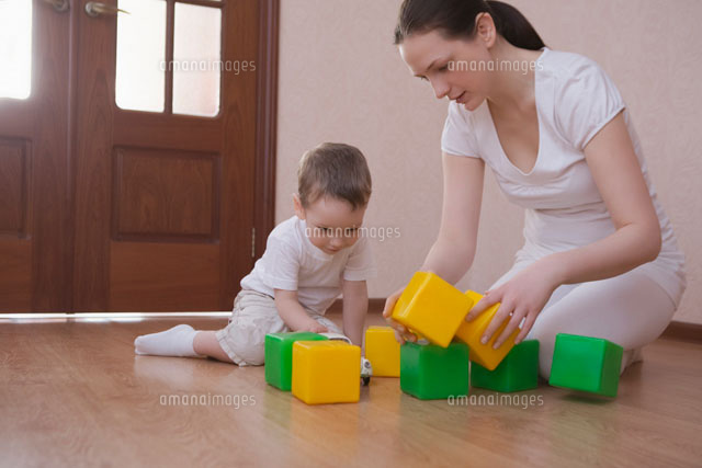 Mother and son play with green and yellow building blocks
(c)moodboard