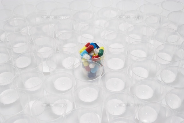 Plastic cup containing pills surrounded by empty glasses
(c)moodboard