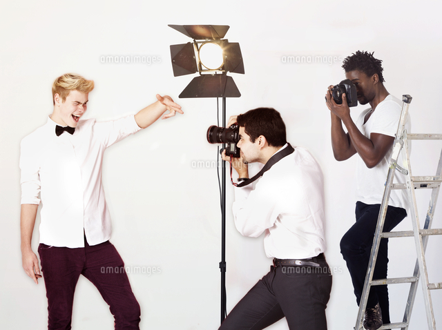 Paparazzi taking photographs of male actor over white background
(c)moodboard