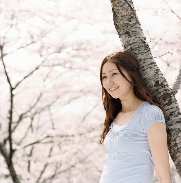 桜の木に寄りかかる女性 の写真素材 イラスト素材 アマナイメージズ