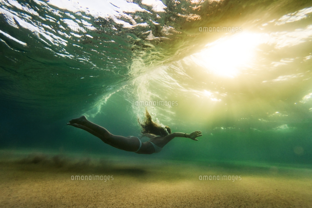 Side view of woman in bikini swimming underwater
(c)Cavan Social