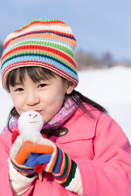 雪だるまにキスをする女の子 の写真素材 イラスト素材 アマナイメージズ