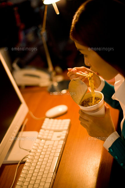 オフィスで夜食を食べる女性
(c)DAJ