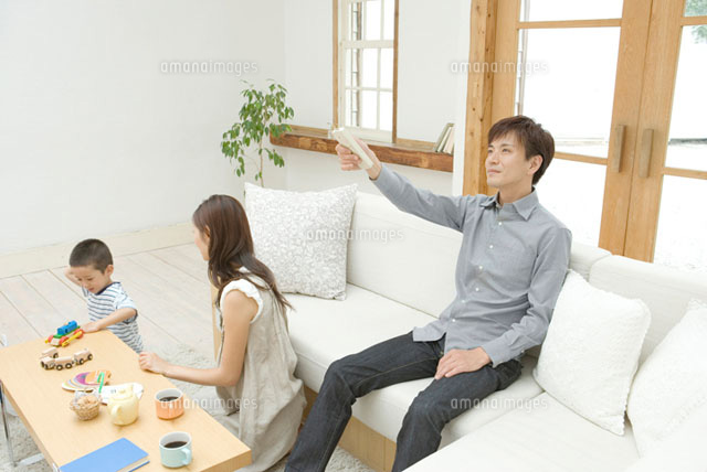 エアコンのリモコンを操作する父親
(c)DAJ
