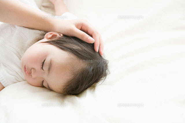 眠っている赤ちゃんを撫でるお母さんの手
(c)daj