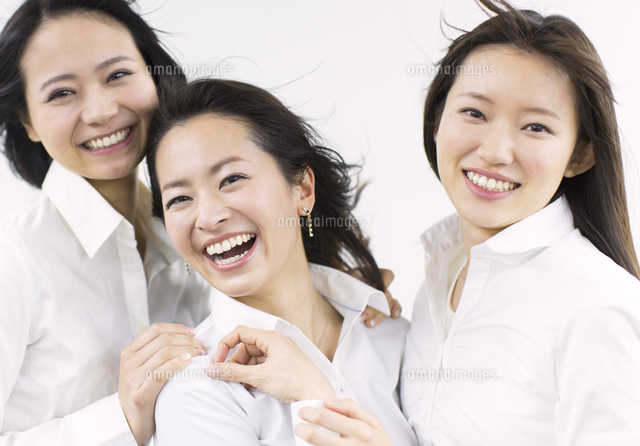 風を受けながら笑う女性３人 の写真素材 イラスト素材 アマナイメージズ