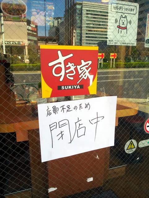 「店員不足のため閉店中」と掲げる店舗=4月上旬、都内の「すき家」