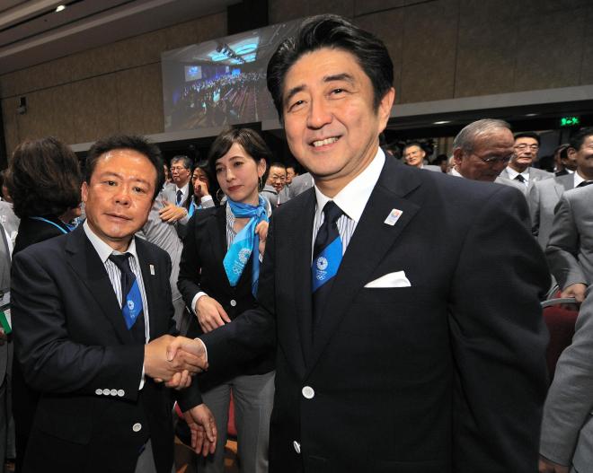 東京での五輪開催決定を受け、ガッチリ握手をかわす安倍首相と猪瀬直樹氏＝2013年9月7日、ブエノスアイレス