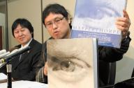 最高裁判決後の記者会見で、メイプルソープ写真集を手にする原告の浅井隆さん(右)と山下幸夫弁護士=2008年2月19日、東京・霞が関の司法記者クラブで