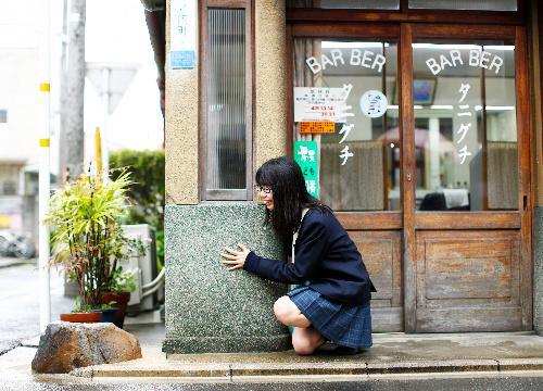 いけず石を愛してやまない高校生の吉田伊織さん。江戸時代の図絵などに見られる「車除（よ）け石」にさかのぼれる可能性が高く現在の目的も車よけが基本だという＝京都市中京区