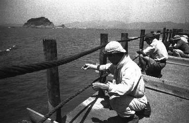 【1948年年夏】日本のエネルギー産業の一翼を担う長崎県の石炭の島「軍艦島」。岸壁から釣り糸を垂らす島民。チヌがよく釣れる
