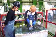 研修で自ら墓石を研磨する若手社員