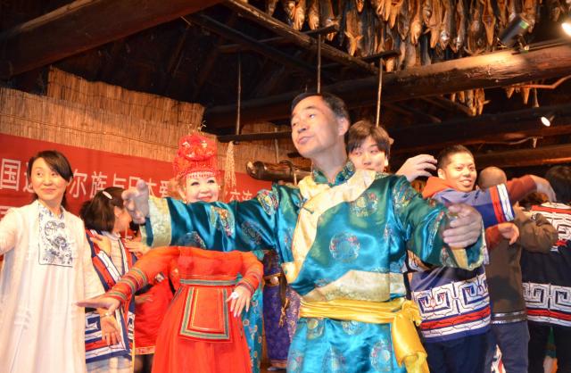 民族衣装でアイヌ民族博物館の職員と一緒に踊る中国ダフール族のメンバーら=2017年5月23日、白老町、深沢博撮影