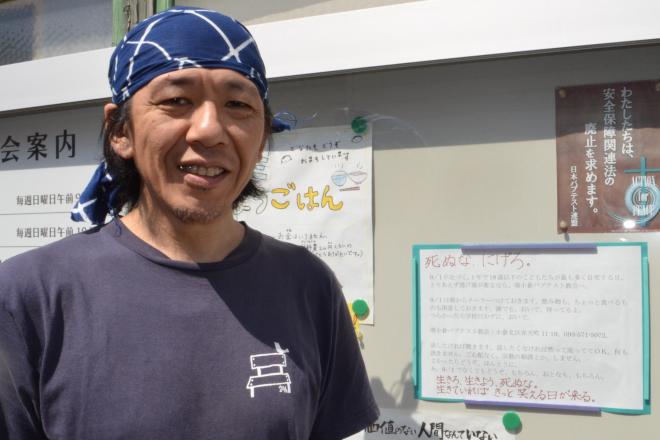 ツイッターで呼びかけた谷本仰さん。教会の前にも「死ぬな、にげろ」と書いたメッセージを掲示している=北九州市小倉北区弁天町